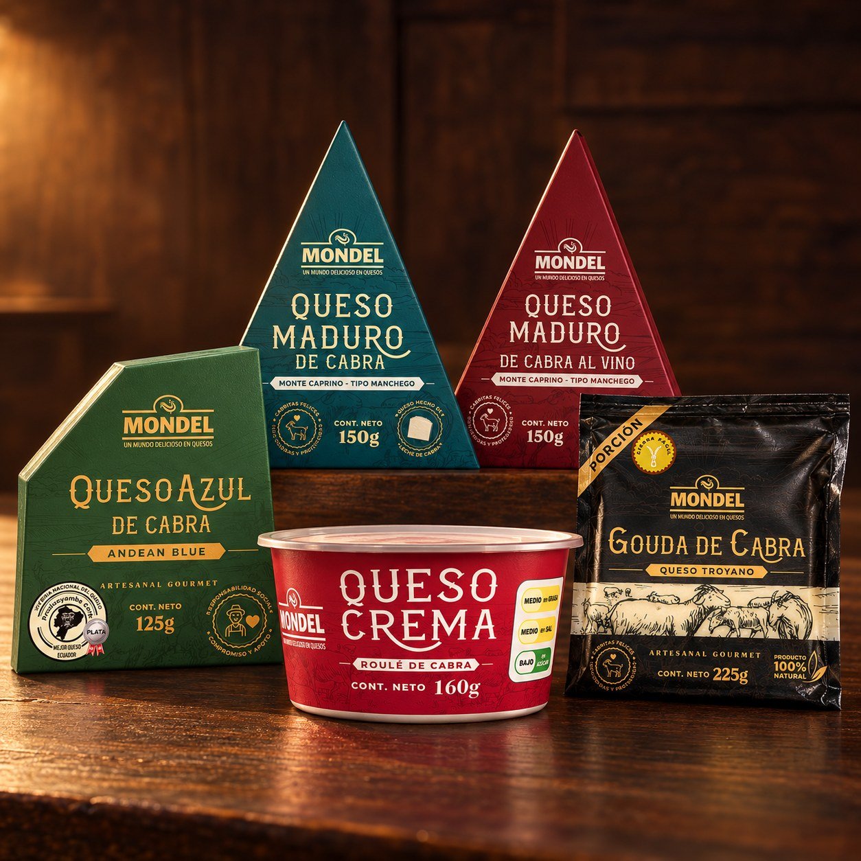 Quesos de Cabra MONDEL — Monte Caprino Quesos de cabra MONDEL sobre mesa de madera: Queso Azul de Cabra Andean Blue 125 g, Queso Maduro de Cabra 150 g, Queso Maduro de Cabra al Vino 150 g, Queso Crema Roulé de Cabra 160 g y Gouda de Cabra 225 g